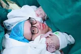 Hi hữu bé gái song sinh chào đời nguyên túi ối