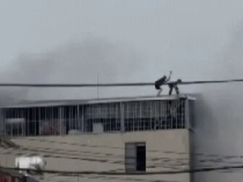 CLIP: Cận cảnh khoảnh khắc nghẹt thở khi 2 người đàn ông phá mái tôn mở đường sống trong đám cháy nhà 7 tầng ở Lĩnh Nam